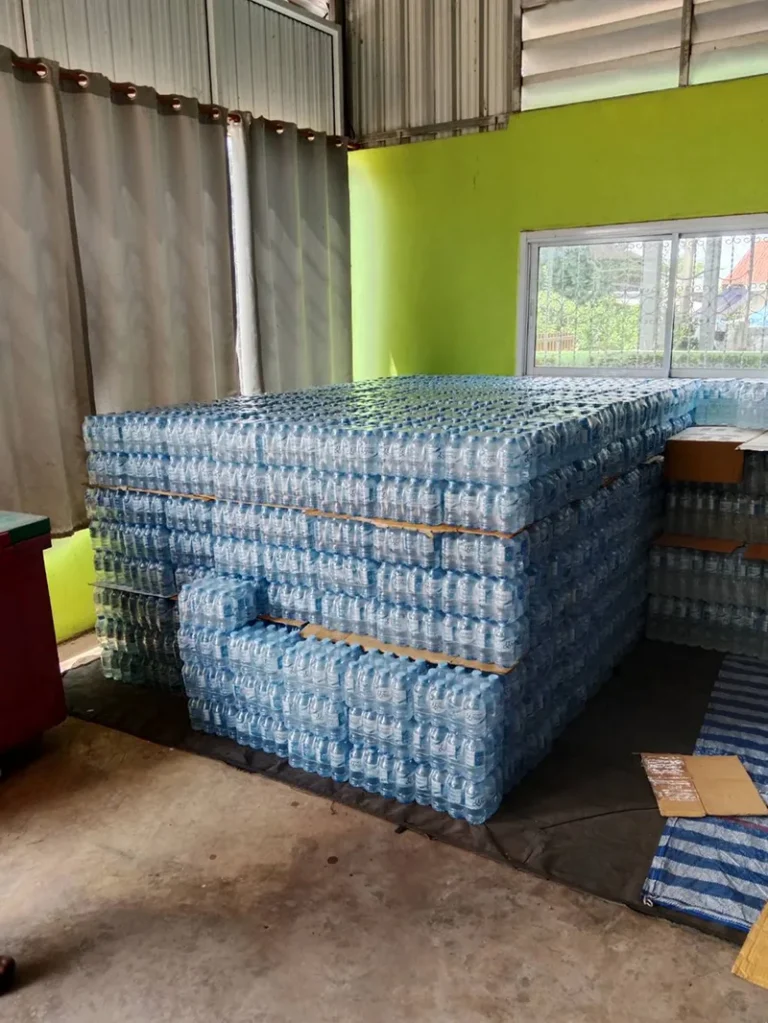 บริการ ส่งน้ำดื่ม มข กังสดาล - หลัง มข. น้ำดื่มราคาส่ง ส่งไวถึงหอพักและร้านอาหาร 4 ขวดน้ำที่บรรจุแล้วเรียงเป็นตั้งๆ ภายในโรงงาน